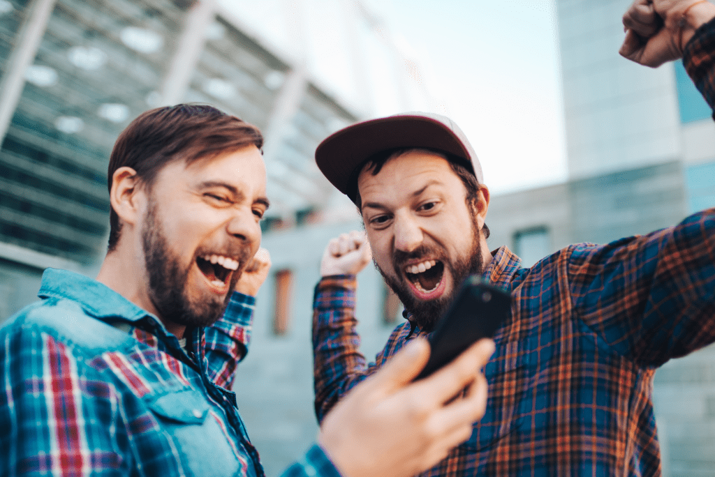 Men holding phone and cheering